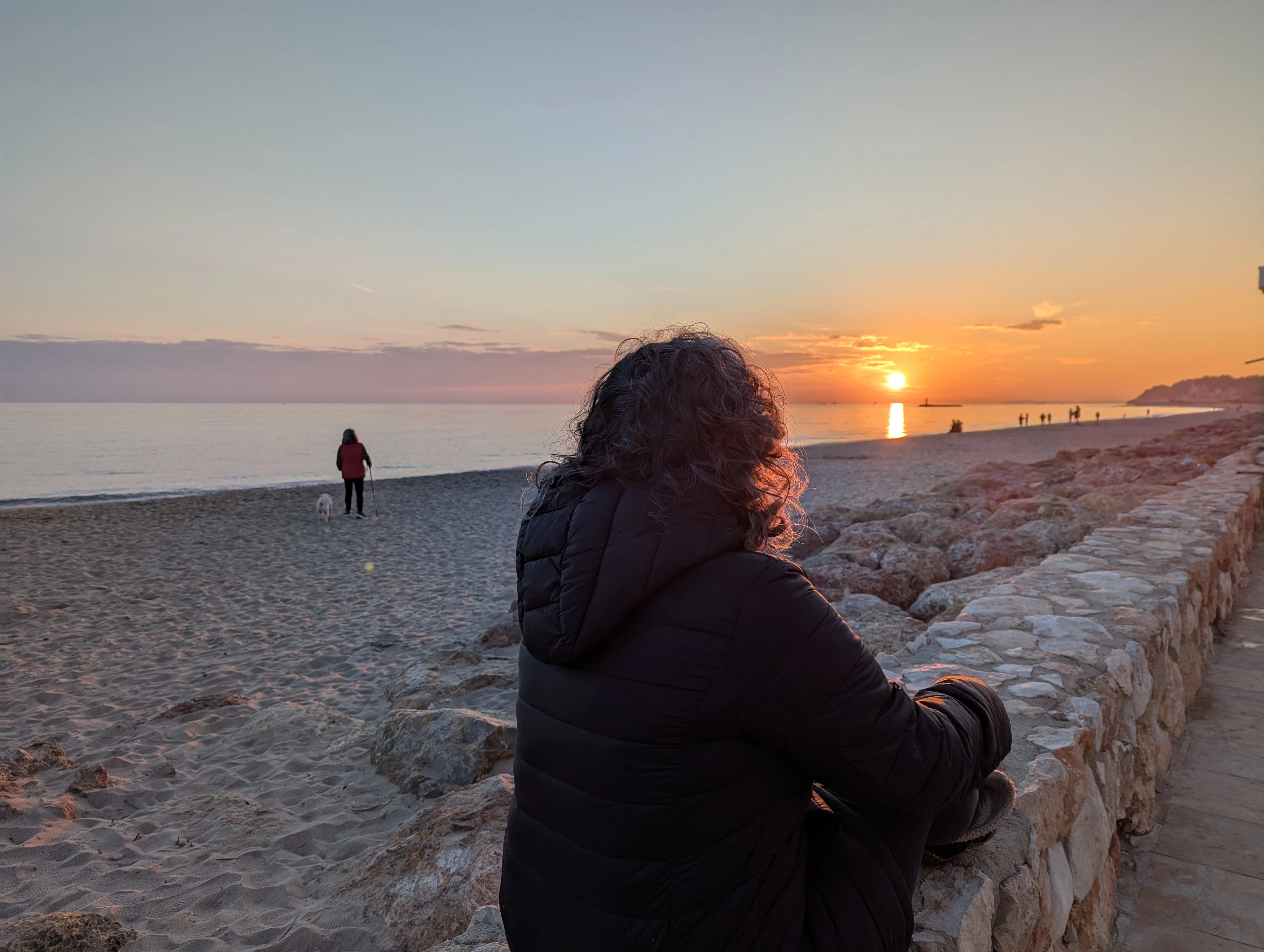 Persona observando el mar durante la puesta de sol